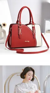 Detail of color-block tote bag in red and beige with top handles and shoulder strap