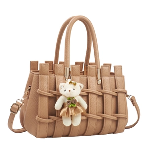 Brown woven leather handbag with plush bear charm and adjustable strap for women