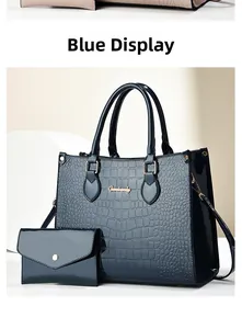 Detail of blue crocodile pattern tote bag set with glossy finish and gold logo