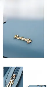 Detail of lychee textured blue leather bag with gold hardware and engraved brand logo