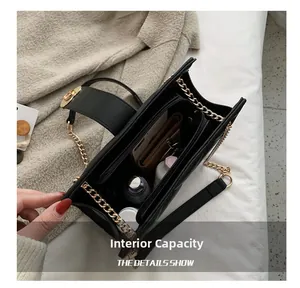 Detail view of large capacity interior compartments in black quilted chain shoulder bag
