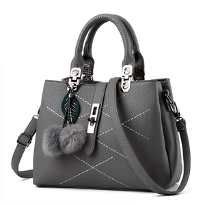 Gray lychee grain PU leather handbag with white stitching and decorative fur ball charm
