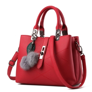 Red lychee pattern leather handbag with diamond stitching and fur pompom accessory