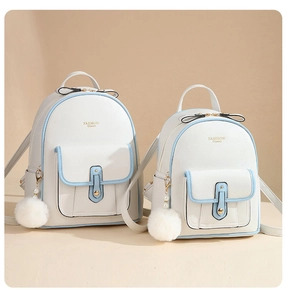 Detail view of pearlescent white soft leather backpacks in two sizes with blue trim