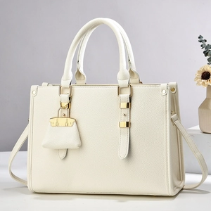 Détail du sac à main en cuir crème avec texture grainée et finitions dorées élégantes