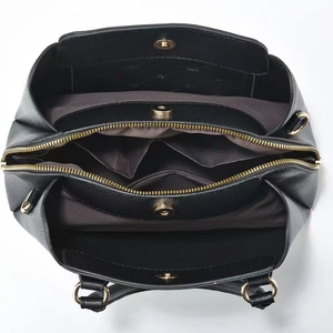 Detail view of large tote bag interior with multiple compartments and gold hardware
