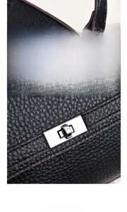 Detail der schwarzen Handtasche aus PU-Leder mit glänzendem silbernem Drehverschluss