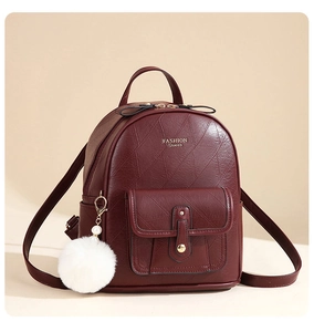 Detail view of burgundy faux leather backpack texture with gold Fashion Queen lettering
