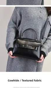 Detail shot of the textured cowhide leather and silver twist lock on the black Kelly bag