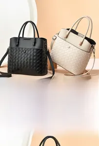 Detail of minimalist woven leather tote bags in black and off-white with metal hardware