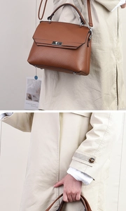 Nahaufnahme der braunen Lederhandtasche mit Litschimuster und silbernem Metalldrehverschluss