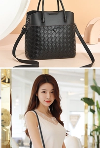Detail of black woven leather tote bag showing texture and adjustable strap on a model