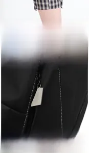 Détail du sac à dos en nylon imperméable montrant la fermeture éclair et le cuir
