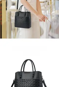 Detail of black woven leather tote bag with dual handles and detachable shoulder strap
