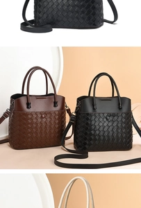Detailed view of woven leather tote bags in black, brown and white on a display tray