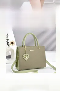 Detail of mint green tote bag featuring heart pearl pendant and fine twill texture