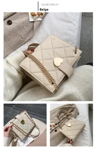 Detail of beige quilted faux leather tote with golden heart buckle and chain strap