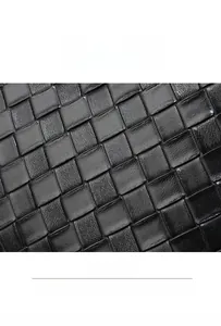 Macro detail of black woven PU leather texture showing diagonal cross pattern craftsmanship