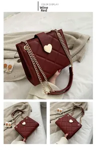 Detail of wine red quilted tote with gold heart buckle and metal chain strap