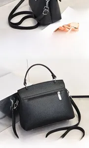 Detailansicht der schwarzen Handtasche mit Lychee-Maserung, Silberzipper und Rückentasche