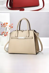 Detailed view of red and beige lychee pattern leather handbags with metal buckle detail