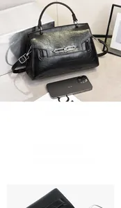 Detailed view of black crossbody bag capacity compared to a smartphone with metallic lock