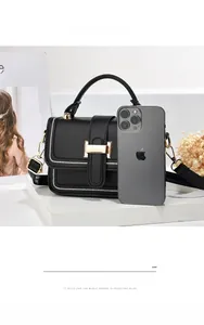 Detaillierter Größenvergleich der schwarzen Lederhandtasche mit einem Smartphone