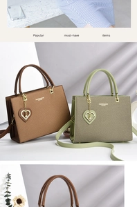 Detail of luxury tote bags in brown and green with gold lettering and pearl heart charm