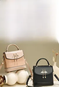 Détail de sacs à main beige et noir avec rayures verticales et boucle en forme de cygne