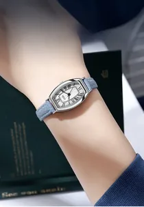 Close-up of vintage tonneau silver watch with Roman numerals and light blue leather strap