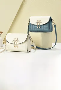 Close-up of quilted crossbody bags featuring golden swan clasps and pearl charm details