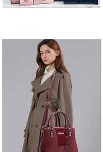 Detail einer burgunderroten Krokodil-Prägetasche, getragen von einem Modell im Trenchcoat