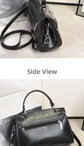 Rear view of black textured leather handbag showing metal zippers and side structure