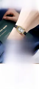 Close-up of retro tonneau quartz watch with roman numerals and black leather strap