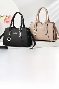 Close-up of litchi grain leather texture and heart shaped crystal charm on women handbag