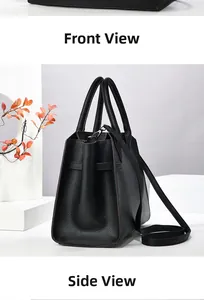 Detail view of black lychee grain leather handbag with side straps and detachable shoulder strap