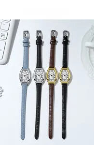 Close-up of vintage tonneau quartz watches with Roman numerals and leather straps