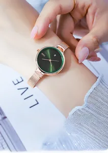 Détail de la montre à maille or rose avec cadran vert soleil et guichet de calendrier