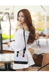 Detail of shell-shaped crossbody bag with floral gradient design and metal zipper