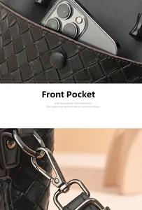 Detail view of woven black tote bag featuring a front pocket and metal hook hardware