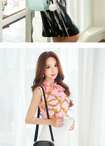 Close-up of a pink chain print shirt paired with a white skirt and a black crossbody bag