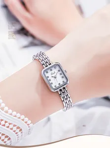 Vue détaillée de la montre quartz carrée argentée avec index diamantés sur le poignet