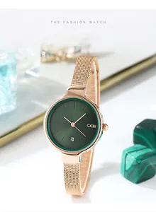 Détail d'une montre en maille or rose avec cadran vert et guichet de date