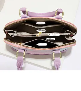 Internal view of shell bag showing main pockets, central zipper compartment, and gray lining