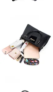 Details zur hohen Kapazität der Handtasche mit Krokodilprägung und Alltagsgegenständen