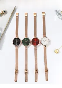 Vue verticale de montres à quartz élégantes avec bracelet en maille or rose et dateur