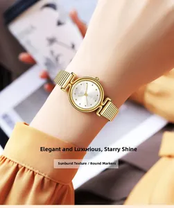 Elegante goldene Quarzuhr mit Sonnenschliff-Zifferblatt und runden Indizes am Handgelenk einer Frau