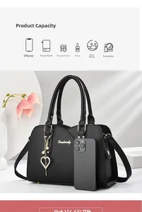 Detail of black lychee texture leather handbag with gold logo and heart charm