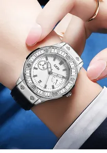 Macro detail of GEDI watch showing rhinestone bezel and black leather strap on wrist