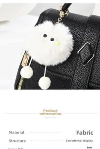 Gros plan d'un bijou de sac monstre en peluche blanche aux grands yeux sur sac noir